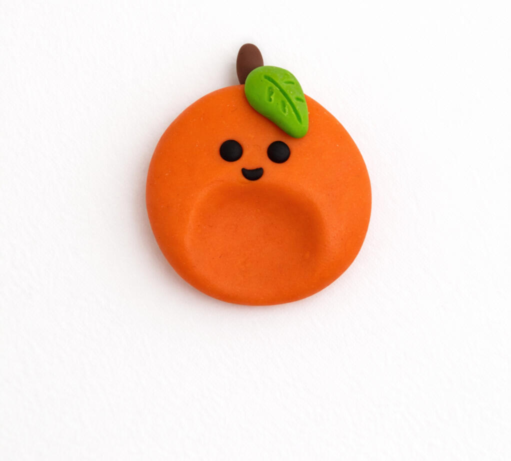 smiling orange worry stone with leaf